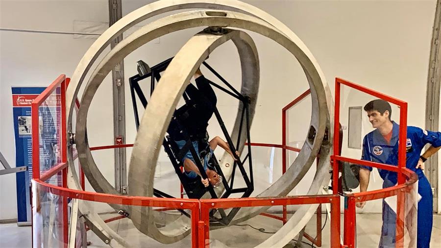 Director Tai is upside down in the Multi Axis Trainer.